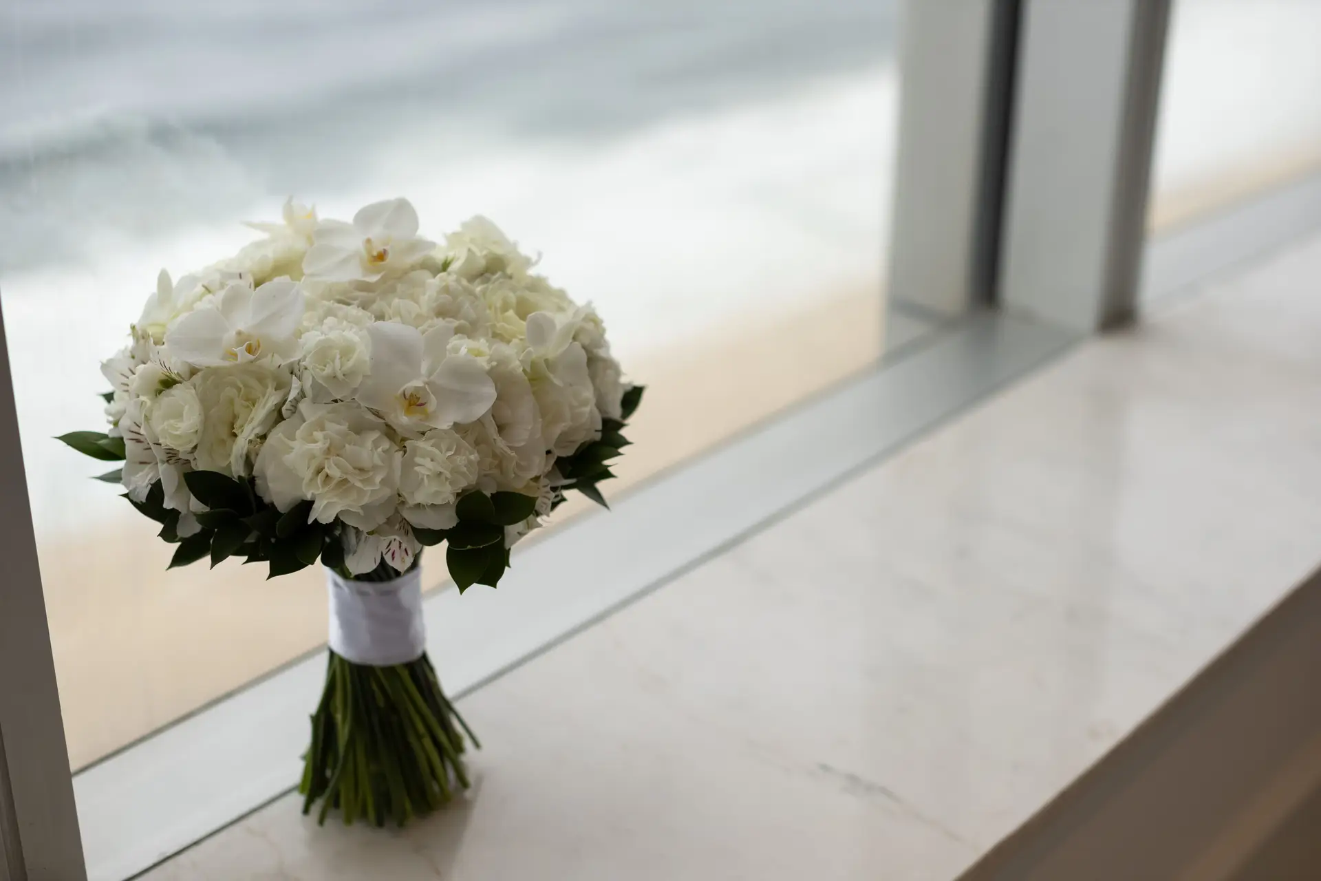 Elegant white rose bouquet on a marble windowsill
